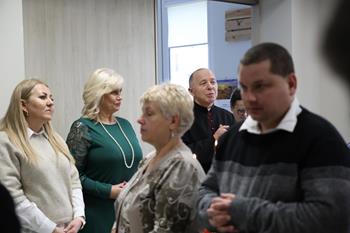 Grupa osób ze złożonymi dłońmi podczas modlitwy